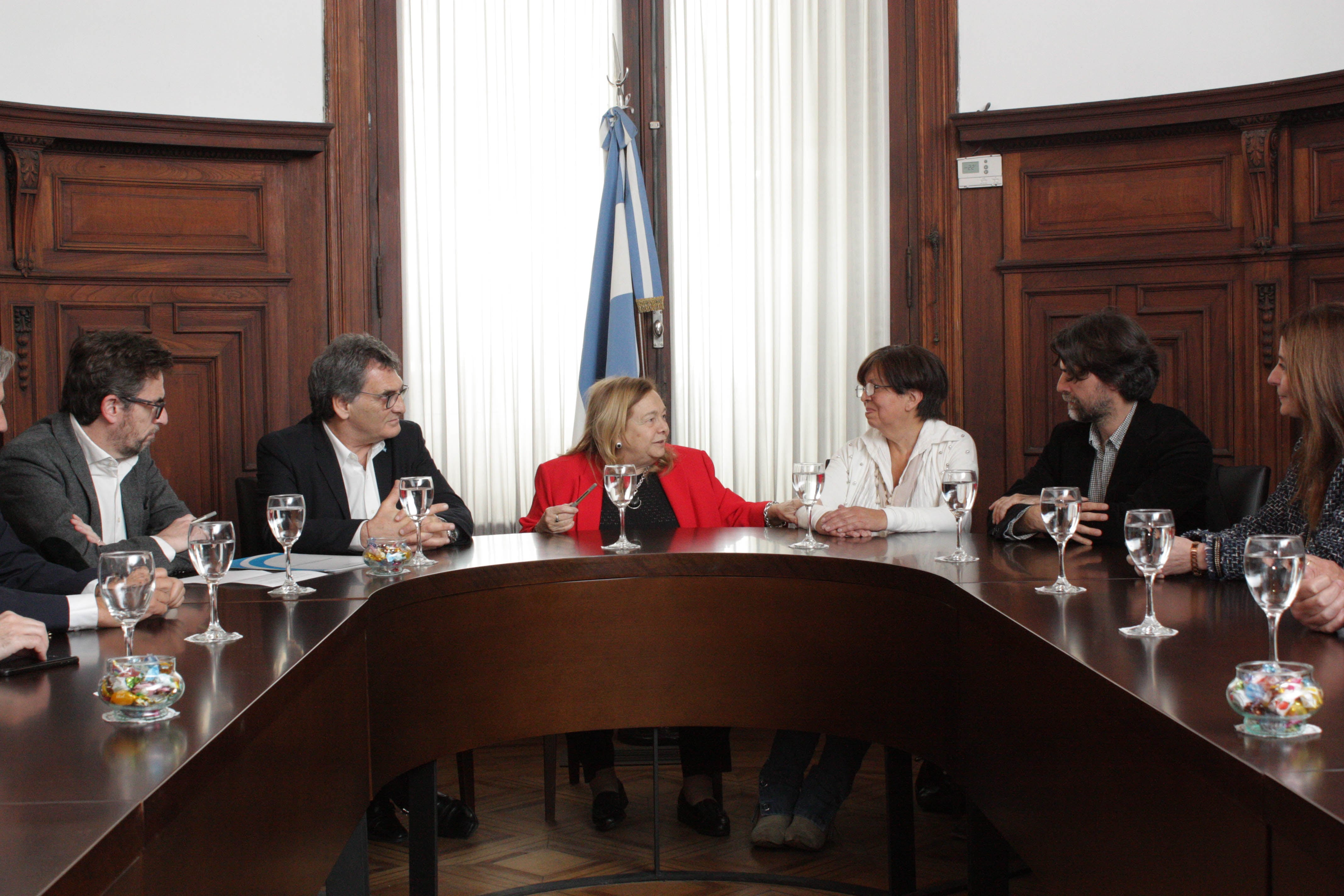 Olga Díaz, de blanco, acompañada por Stella Maris Martínez, logró el reconocimiento del Estado, representado por Claudio Avruj.