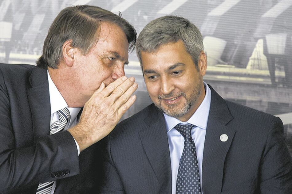 Bolsonaro habla al oído de Abdo Benítez en la represa de Itaipú.