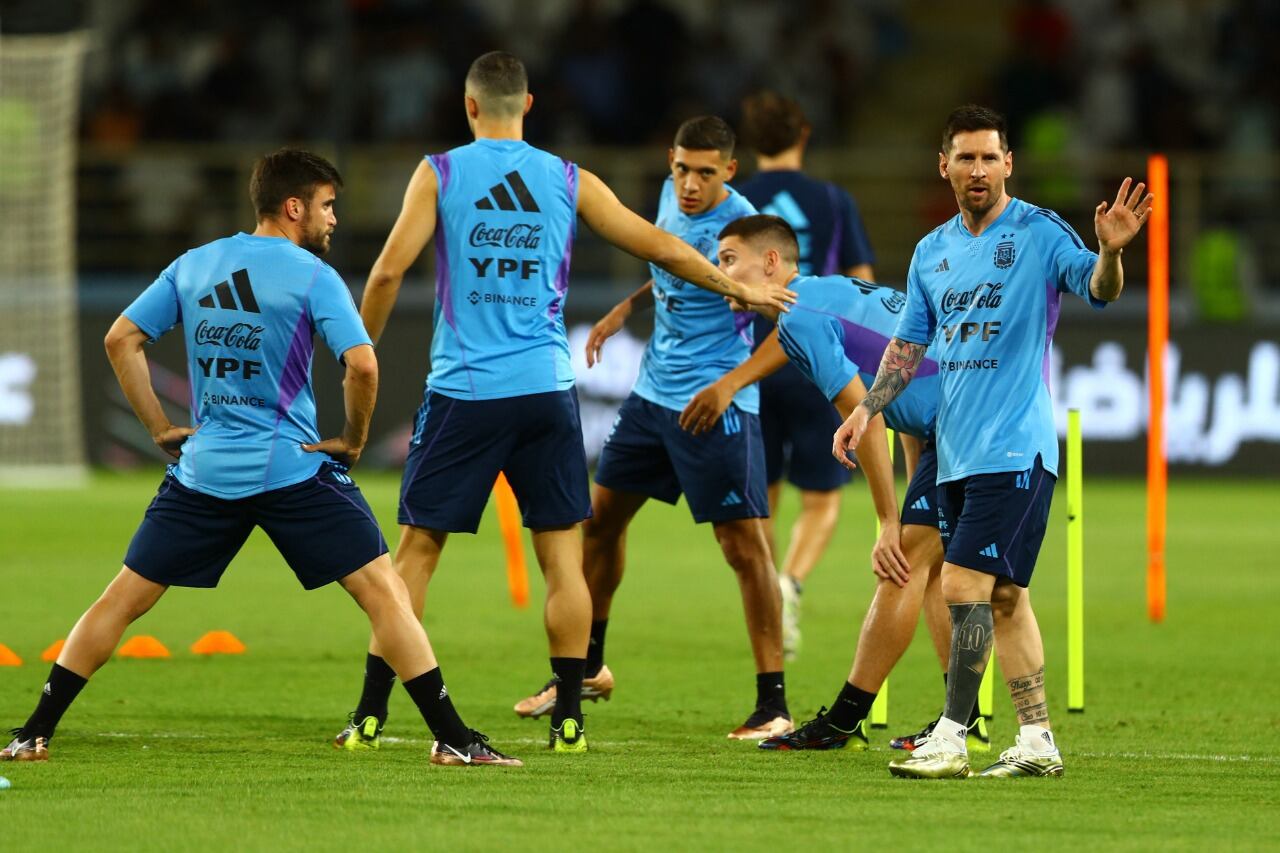 Lionel Messi saluda; los laterales Nahuel Molina y Nicolás Tagliafico lo observan