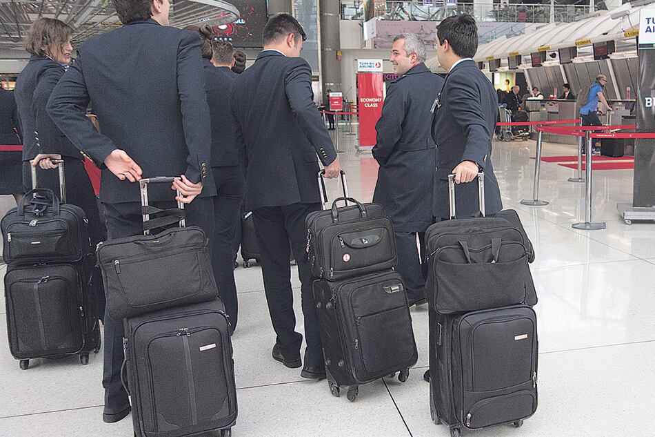 Pasajeros hacen cola en un mostrador después de la prohibición de transportar aparatos electrónicos de ciertos países.