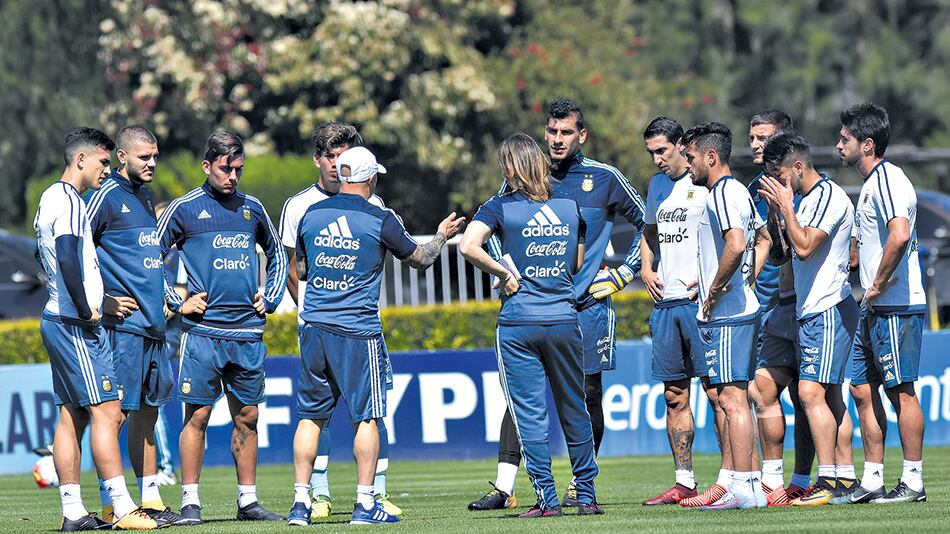 El DT y su ayudante de campo dialogan con el grupo de suplentes en Ezeiza.