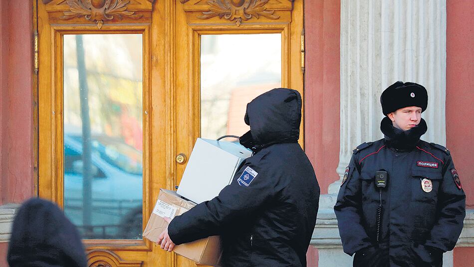 Un agente de seguridad retira cajas del consulado general de EE.UU. en San Petersburgo.