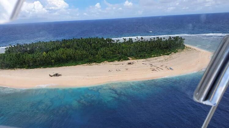 Vista área de la pequeña isla de Micronesia donde quedaron varados los tres hombres y el SOS en la arena. 