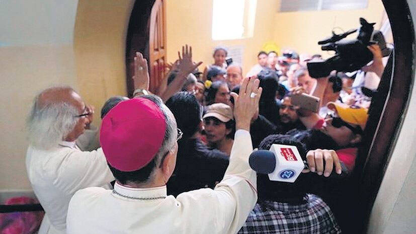 El cardenal Brenes, a la izquierda, tratando de frenar una toma de la iglesia de San Sebastián, en Diriamba.