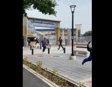 Los estudiantes corren en la puerta de la Universidad de Guayaquil ante el ataque del grupo comando. (Foto: Captura de video)