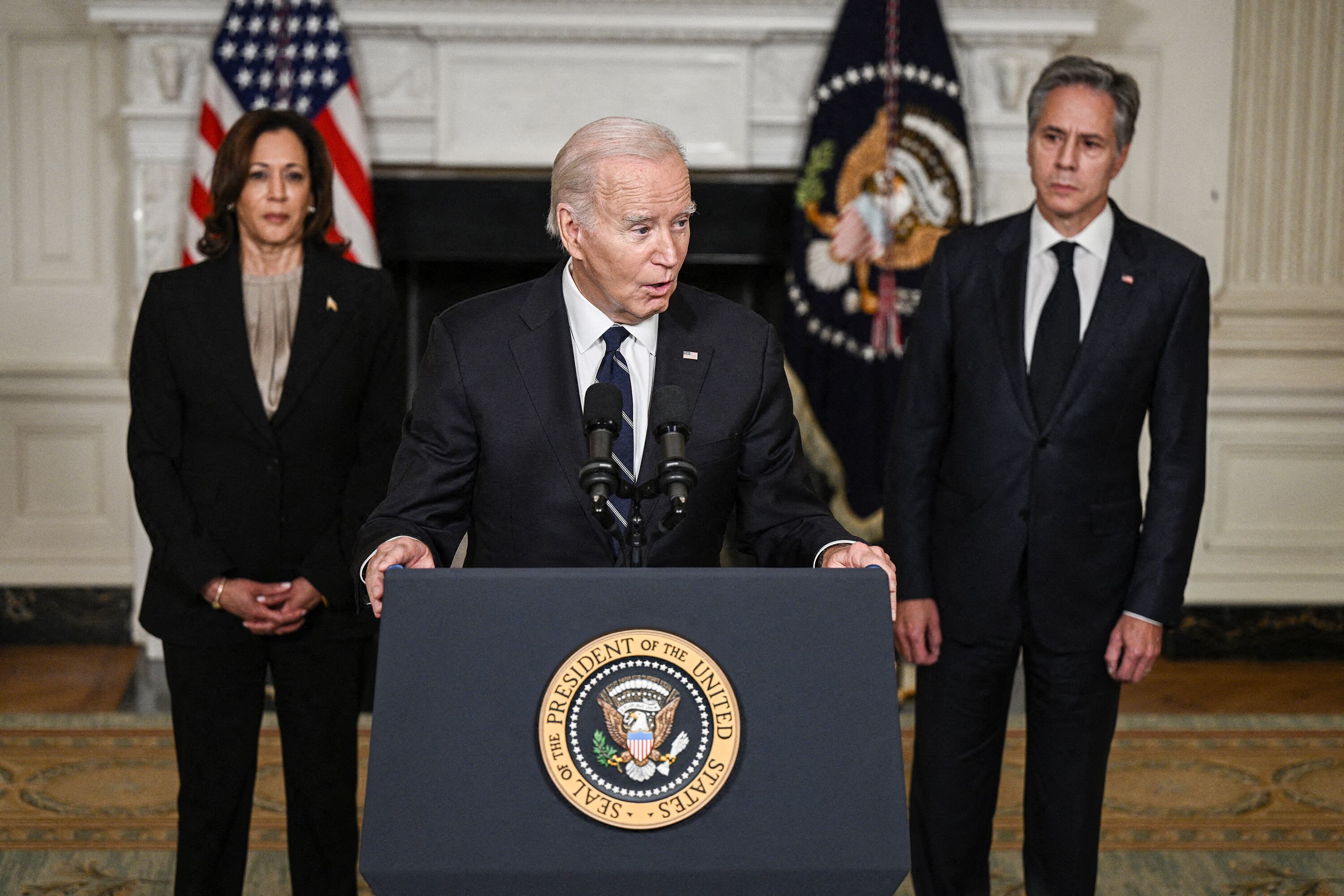 Flanqueado por su vice Harris y su canciller Blinken, Biden habla desde la Casa Blanca. 