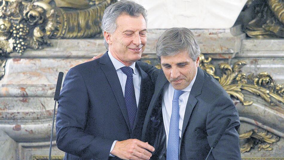 El ministro de Finanzas, Luis Caputo, en un día florido con el Presidente Mauricio Macri. Ahora no le llueven flores sino denuncias.