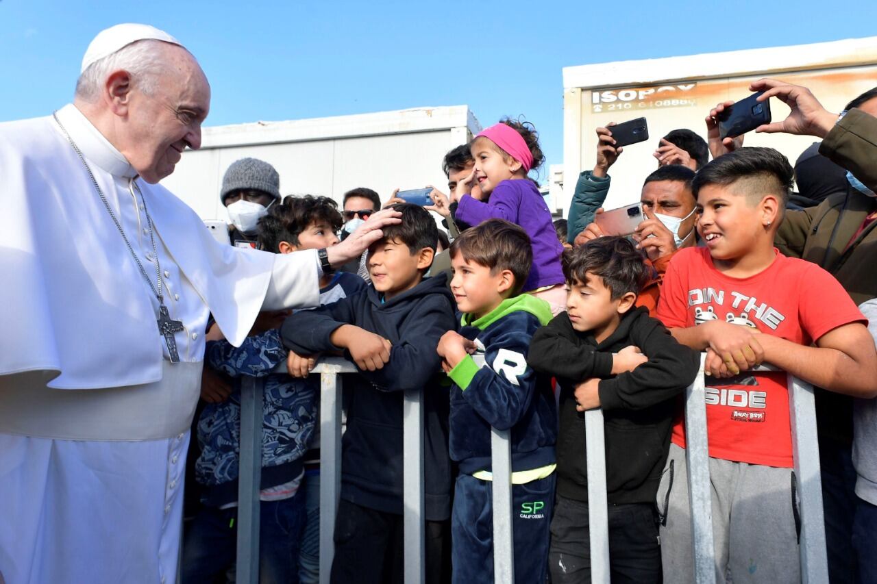 El Papa saluda aun niñomigrante en Lesbos, Grecia.