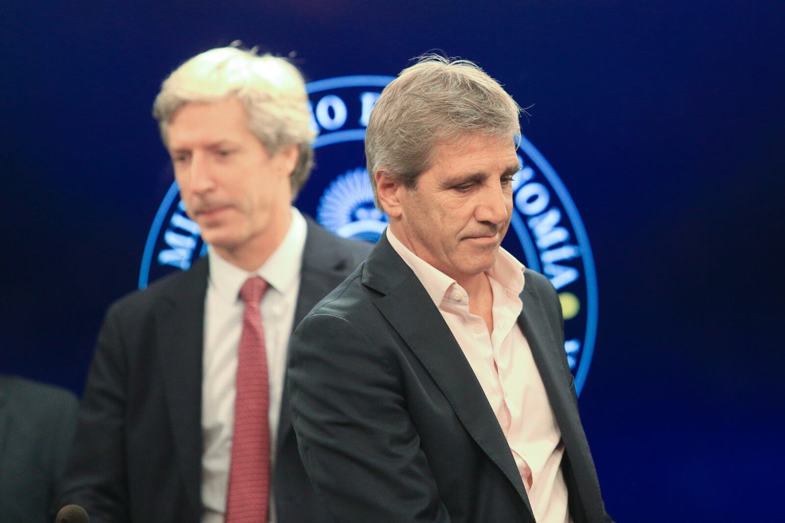 El ministro de Economía, Luis Caputo, y detrás de él, su socio y presidente del Banco Central, Santiago Bausili.