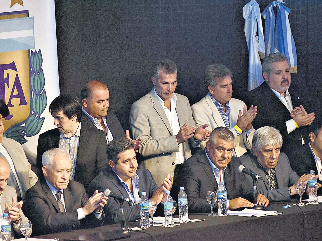 Claudio Tapia (entre Angelici y Moyano), junto a sus compañeros de la única lista que se presentó a la elección en el marco de la Asamblea Extraordinaria.