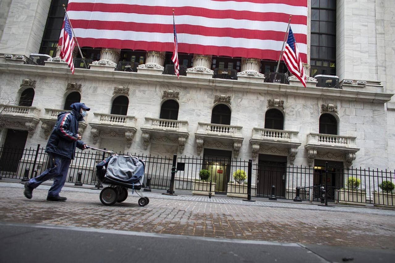 Un hombre empuja un carrito frente a la Bolsa de Comercio de Nueva York.