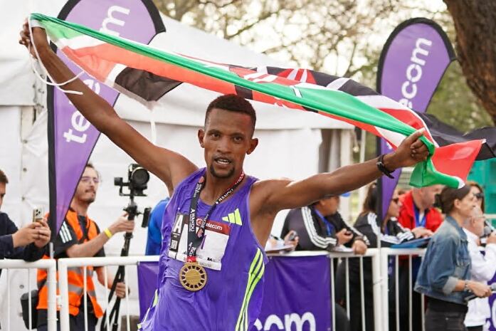 Bethwell Yegon alza las manos con la medalal y la bandera de Kenia