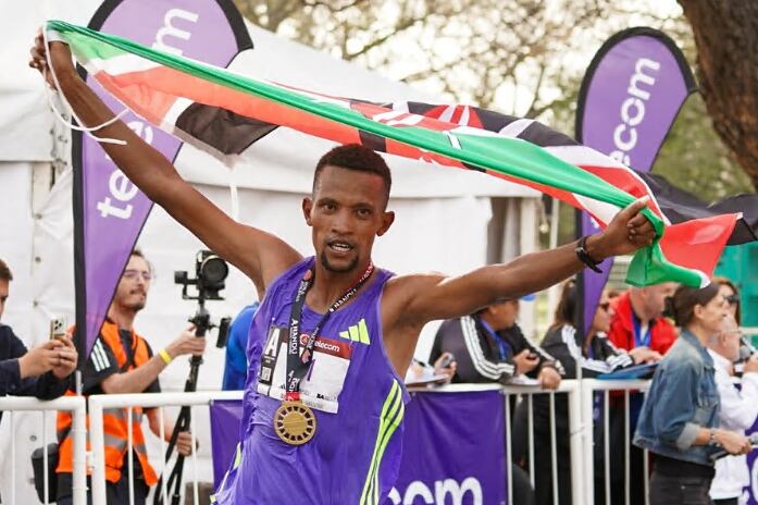 Bethwell Yegon alza las manos con la medalal y la bandera de Kenia