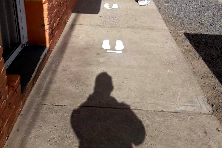 Así están las veredas de Roque Pérez para que la gente sepa dónde pararse para respetar la distancia interpersonal con el otro.