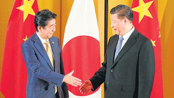 Xi Jingpin y el presidente japonés, Shinzo Abe, se dan la mano en un encuentro bilateral.
