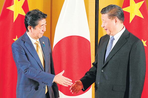 Xi Jingpin y el presidente japonés, Shinzo Abe, se dan la mano en un encuentro bilateral.
