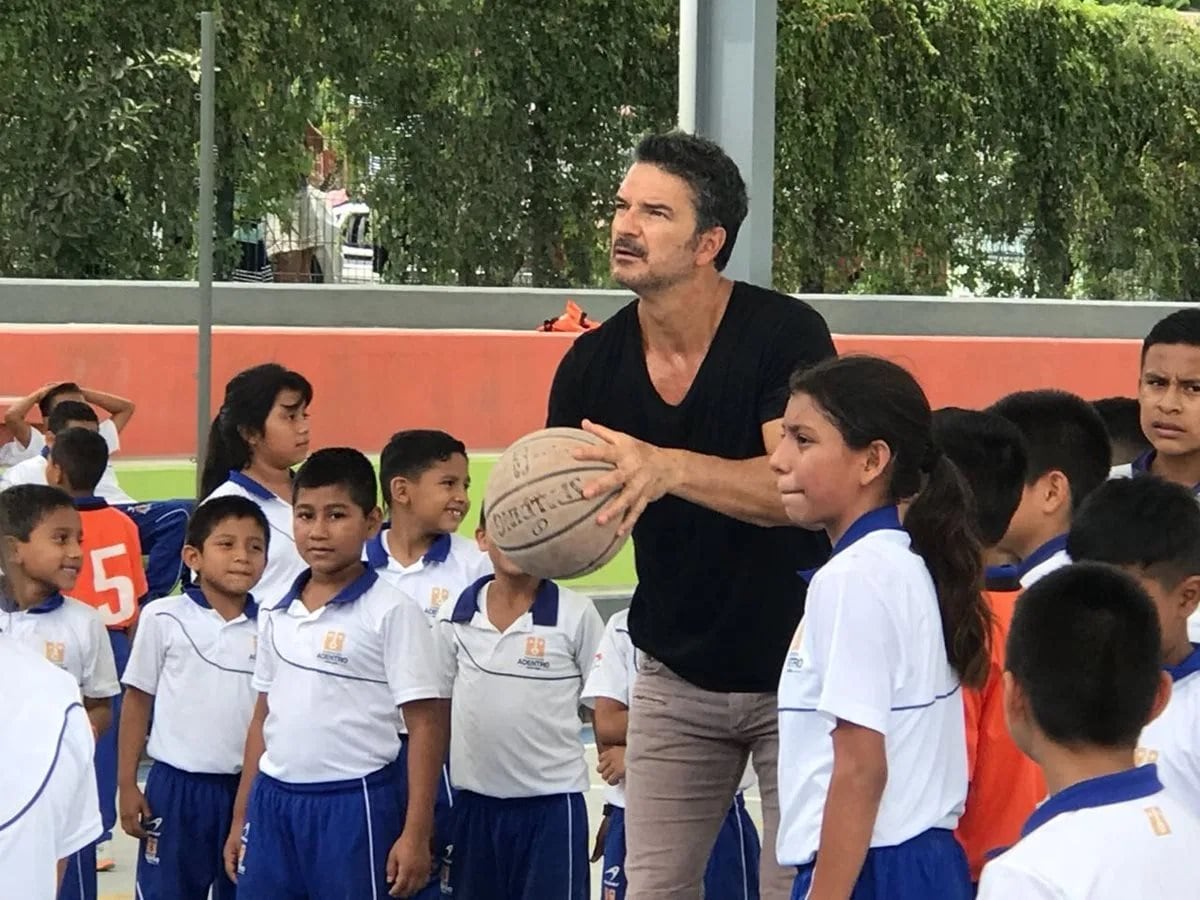 Ricardo Arjona, tira al aro tras una visita a una escuela.