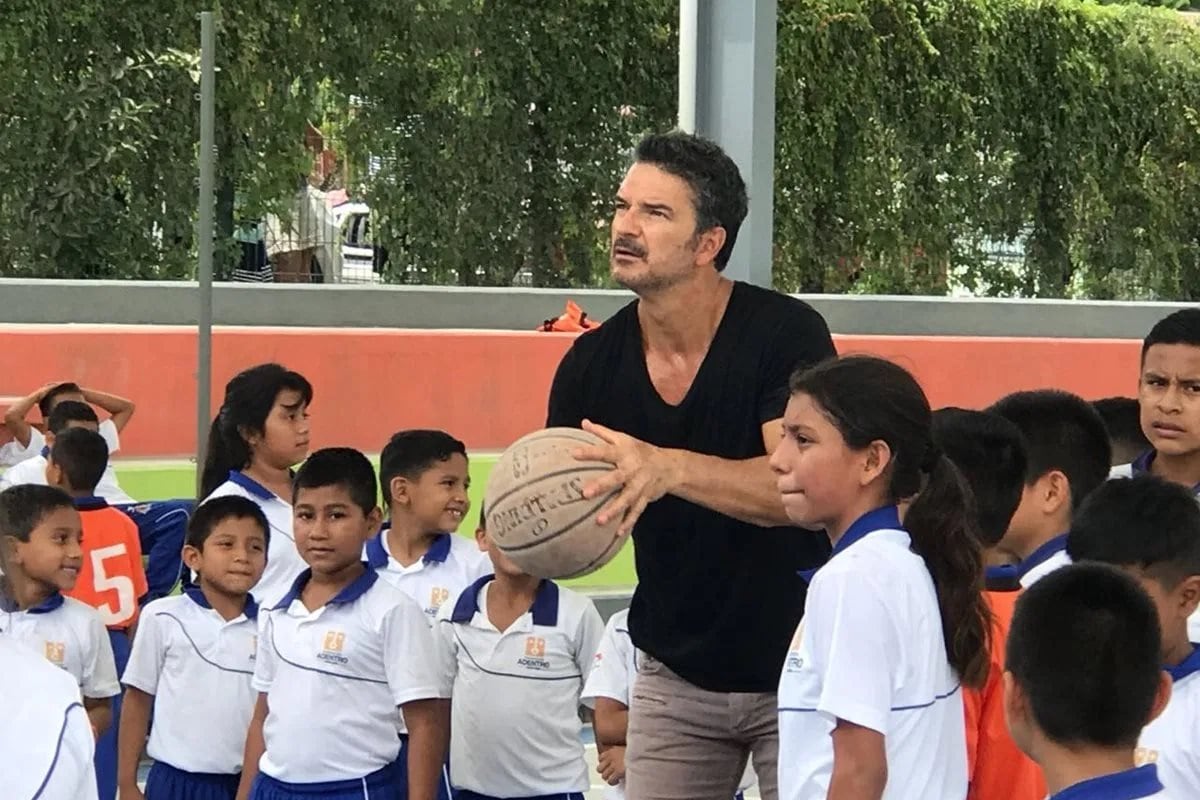 Ricardo Arjona, tira al aro tras una visita a una escuela.
