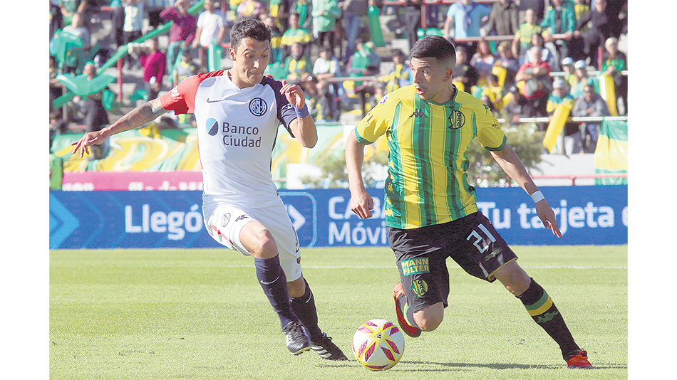 Emanuel Iñiguez lleva la pelota ante la presión de Botta.