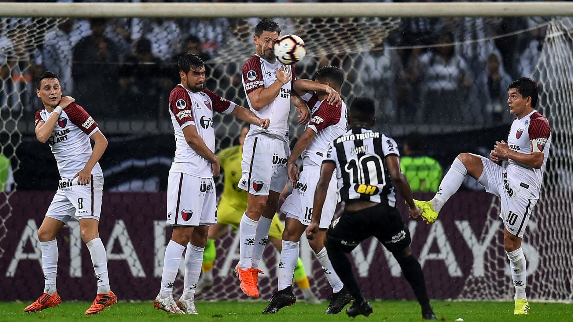 Cazares intenta superar de tiro libre la barrera de Colón.