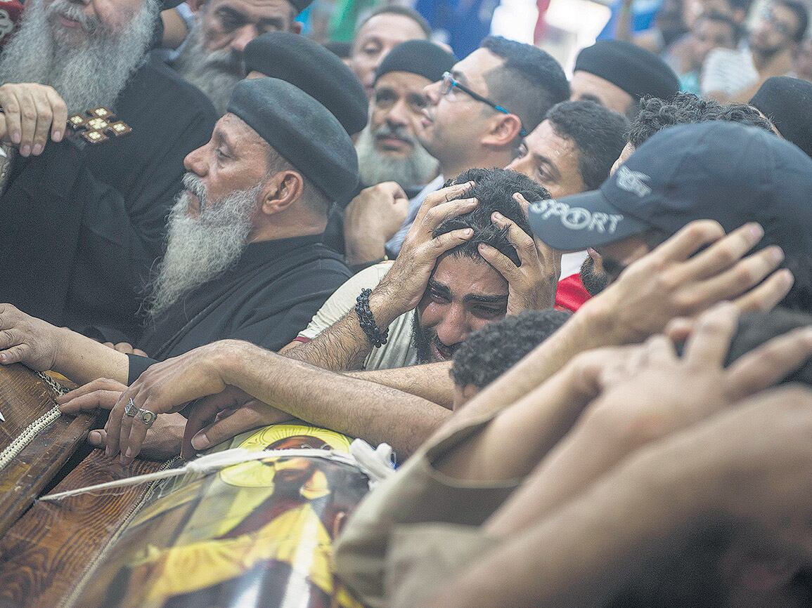 Familiares lloran durante el funeral de una de las víctimas del ataque en la entrada al monasterio de San Samuel.