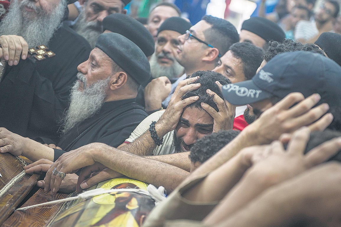 Familiares lloran durante el funeral de una de las víctimas del ataque en la entrada al monasterio de San Samuel.