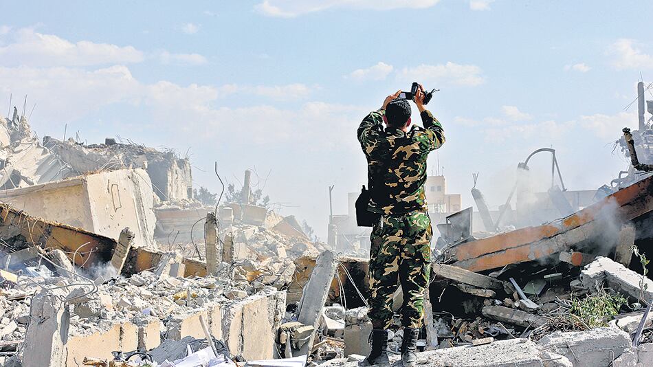 Un soldado sirio inspecciona las ruinas del edificio que era parte de un centro de investigación científica en Damasco.