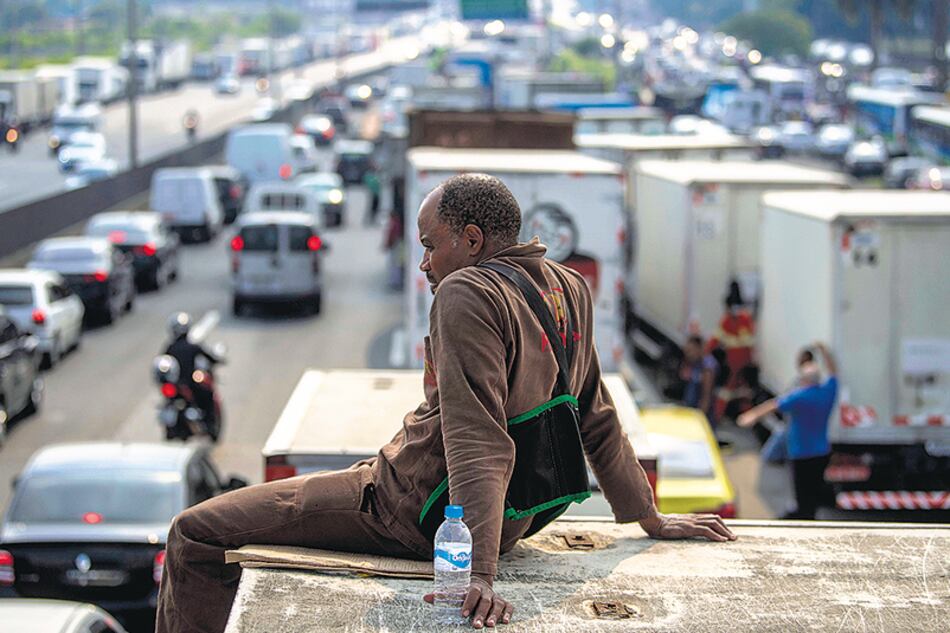 Un camionero observa el bloqueo de una autopista en la entrada a Río de Janeiro, donde ya se siente el desabastecimiento de insumos básicos.