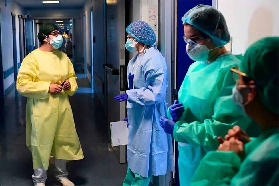 Crsitina Petri, (izq.) jefa delimieza del hospital de Cremona,habla con médicas deterapia intensiva.