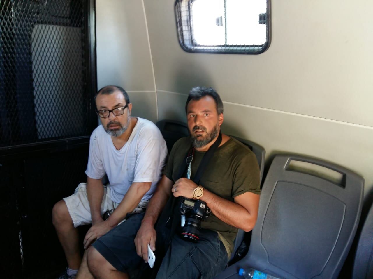 Bernardino Ávila (izquierda) detenido en un celular, junto a otro colega.