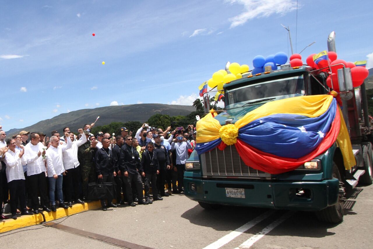 Petro y elministrode Transporte venezolano Ramon Velasquez obsevan cómo el primer camión venezolano cruza la frontera.