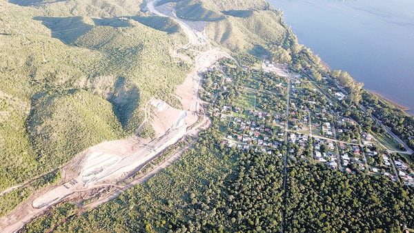 La traza de la autovía se abre como un surco de tala sobre el verde del monte de las sierras de Punilla.