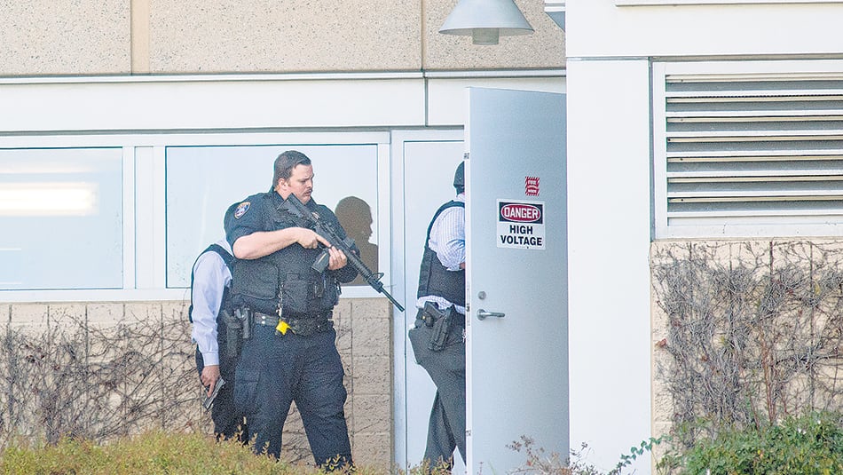 Un policía armado revisa la escena del crimen después del tiroteo en el campus de YouTube.