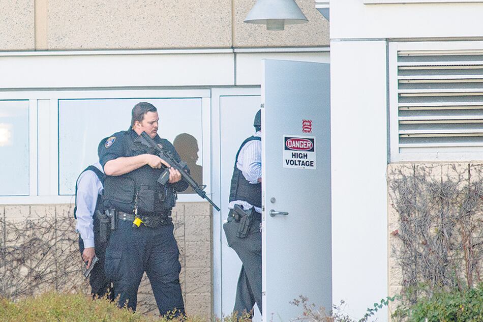 Un policía armado revisa la escena del crimen después del tiroteo en el campus de YouTube.