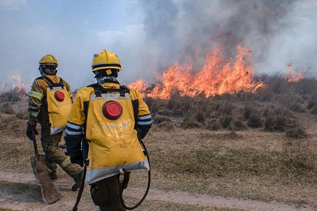 Los bomberos intentan apagar el fuego en expansión.