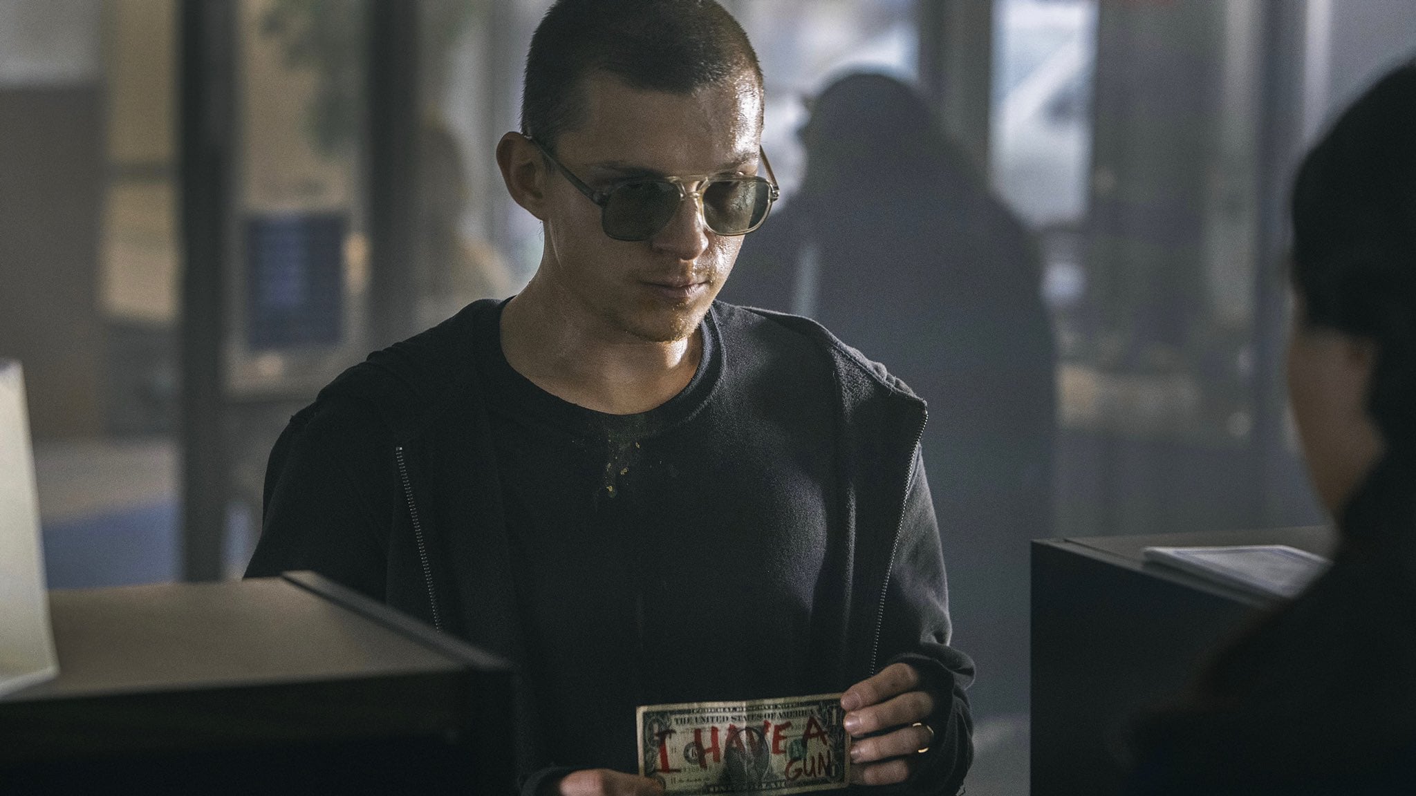 El prólogo encuentra a Cherry (Tom Holland) robando él solito y sin ayuda un banco.
