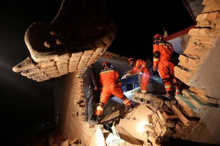 Varios rescatistas buscan supervivientes entre los escombros de una vivienda en la aldea de Kangdiao.