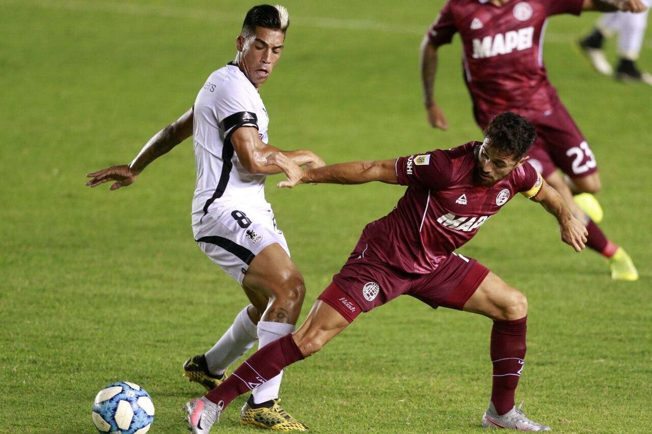 Lautaro Acosta lucha por la pelota con Fittaioli.
