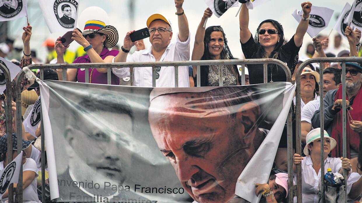 Admiradores del Papa saludan desde la tribuna de la misa al aire libre en Villavicencio.