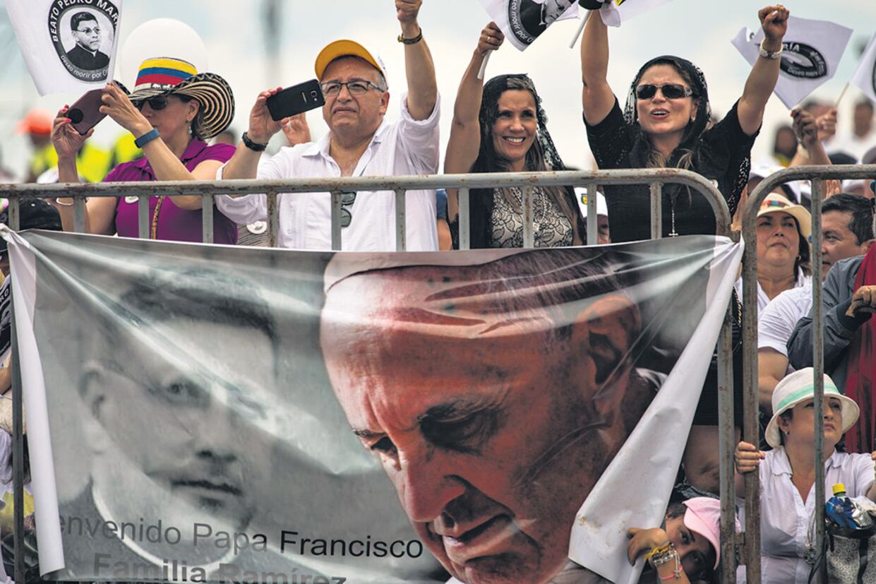 Admiradores del Papa saludan desde la tribuna de la misa al aire libre en Villavicencio.