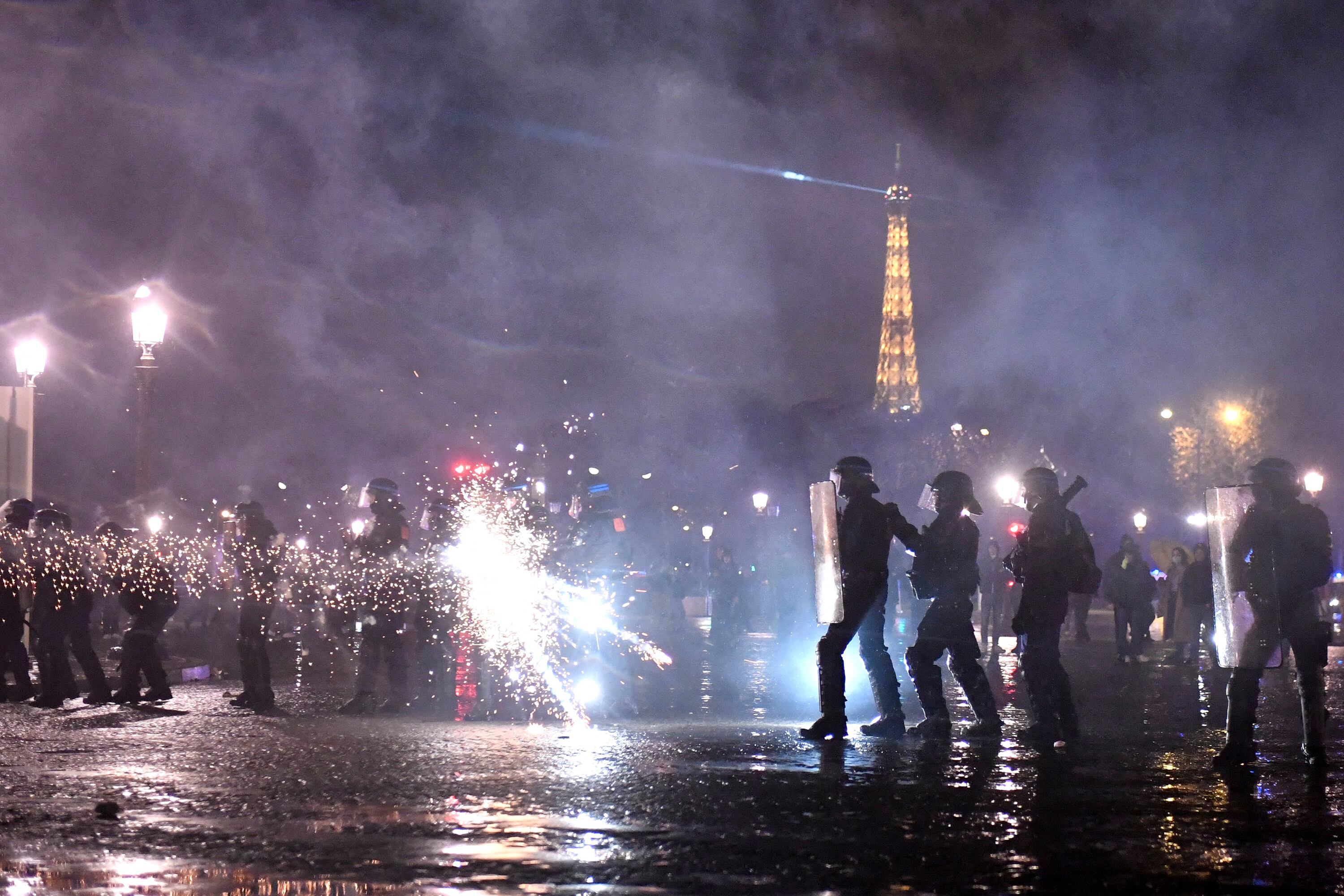 Manifestantes disparan bengalas a policias cerca de la Torre Eiffel.