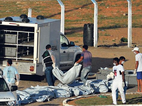 Personal sanitario retira los cuerpos de las víctimas de la pelea entre bandas en el penal de Alcacuz.