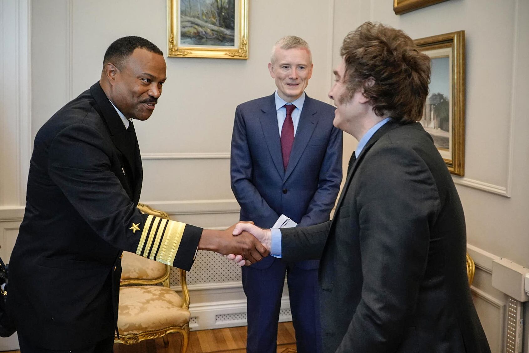 Javier Milei saluda al almirante Alvin Holsey ante la mirada del traductor oficial. 