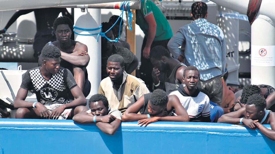 Varios de los 650 migrantes que fueron rescatados esperan para desembarcar en Catania, sur de Italia.