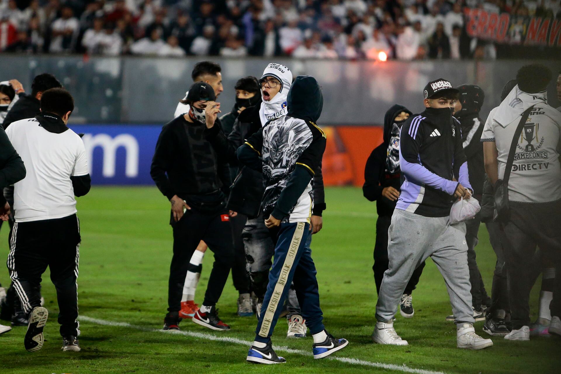 Aficionados de Colo Colo invaden el campo de juego después de la muerte de dos hinchas asfixiados por una avalancha tras una carga policial. EFE/ Osvaldo Villarroel
