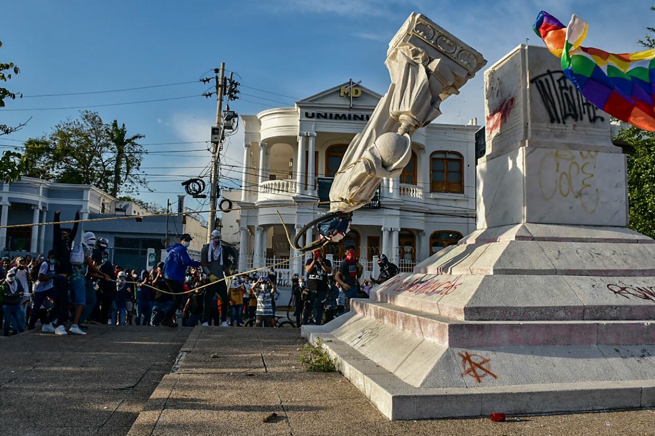 Con la estatua ya caída en el suelo, los manifestantes escribieron consignas sobre la roca, como la leyenda “por nuestros muertos”, y le cortaron la cabeza y las manos.