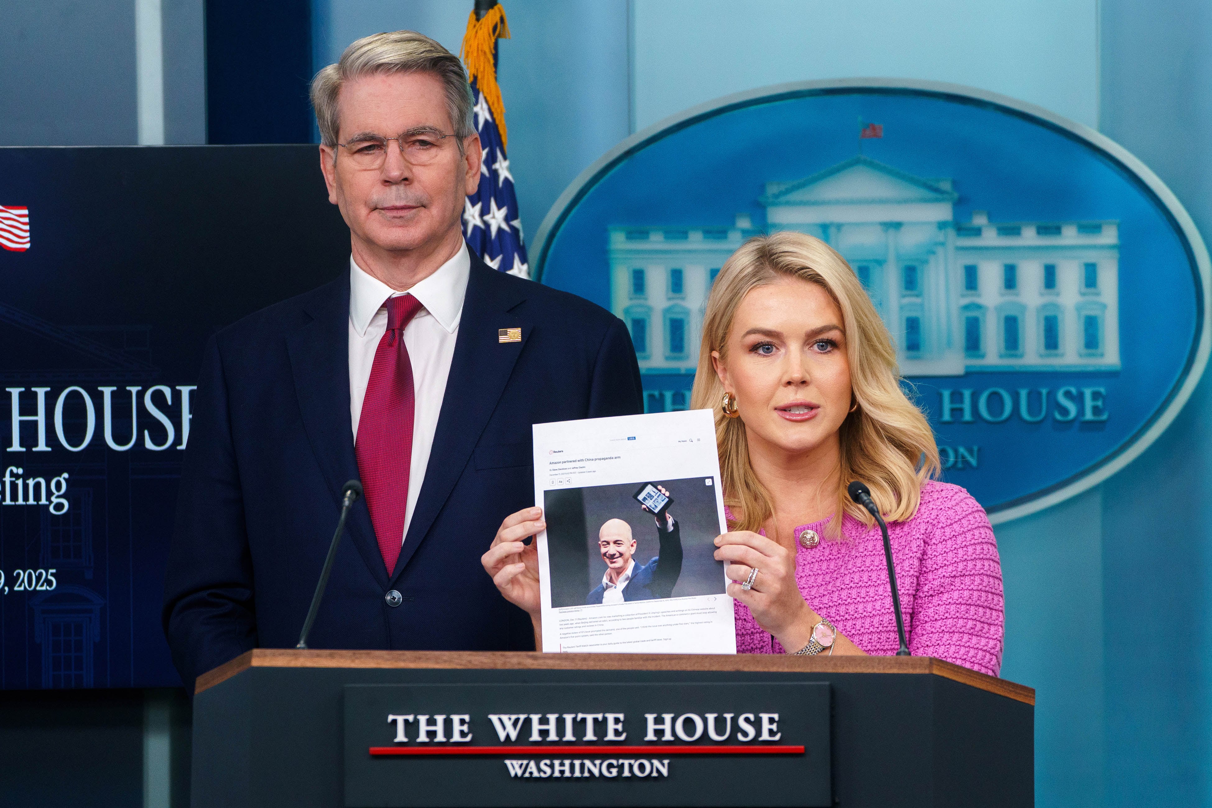 La portavoz de la Casa Blanca sostiene una foto de Bezos mientras el secretario del Tesoro observa.