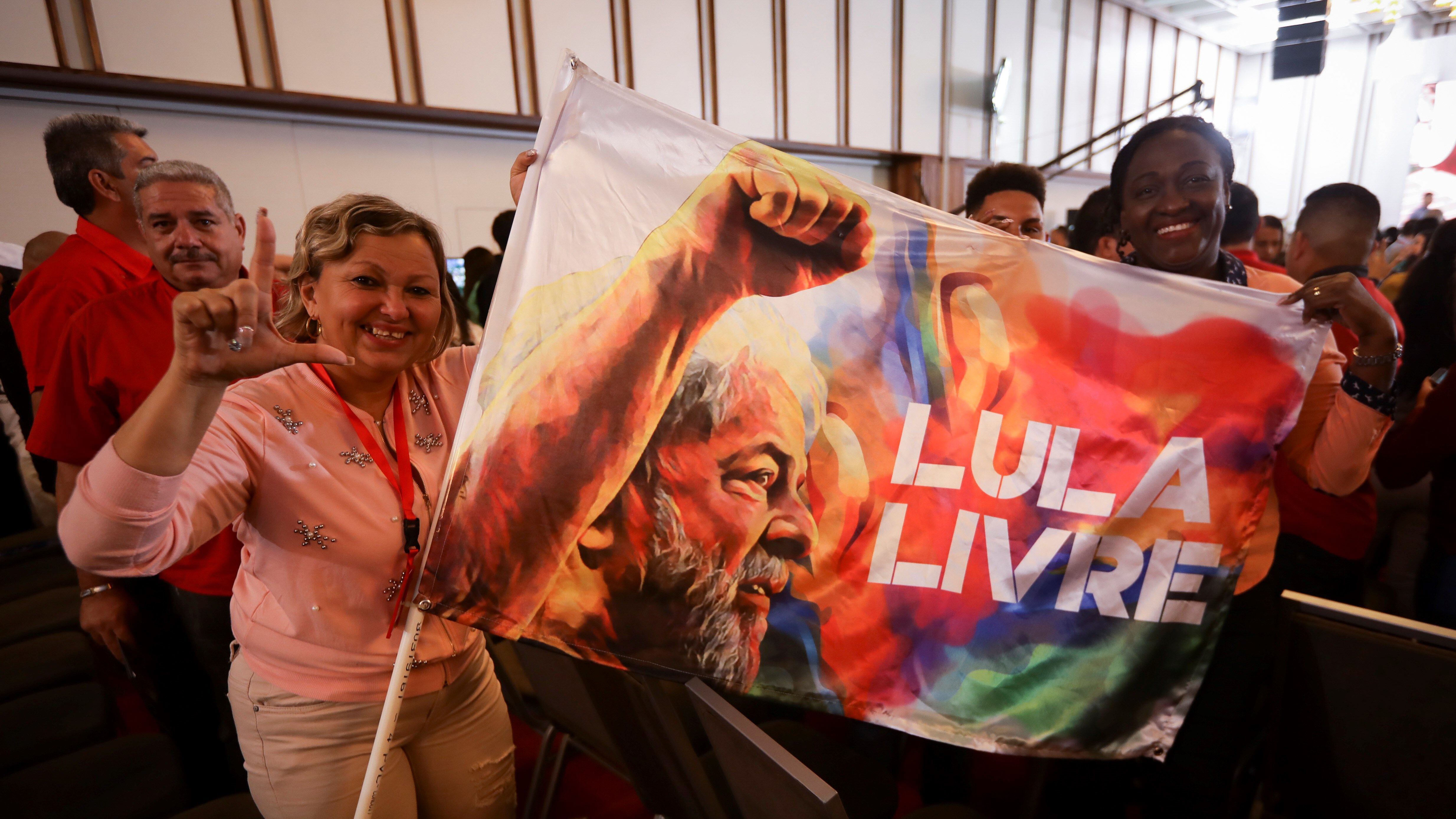 En la jornada inaugural miembros del foro exhiben una bandera exigiendo la libertad de Lula.