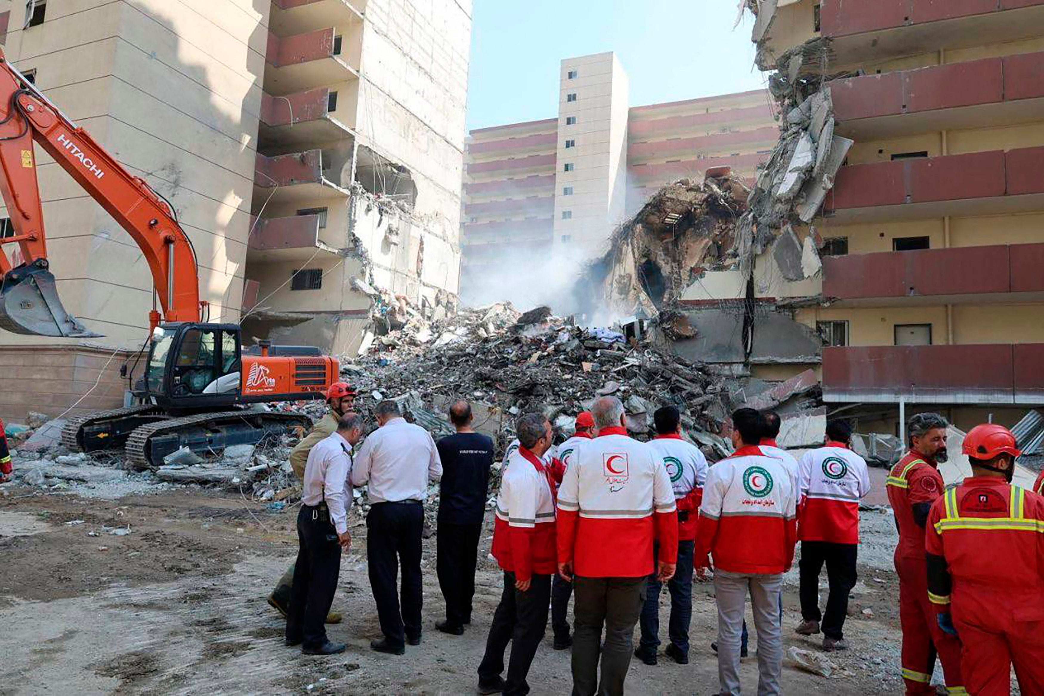 Miembros de la Media Luna Rojaobseran un edificio bombardeado en Teherán