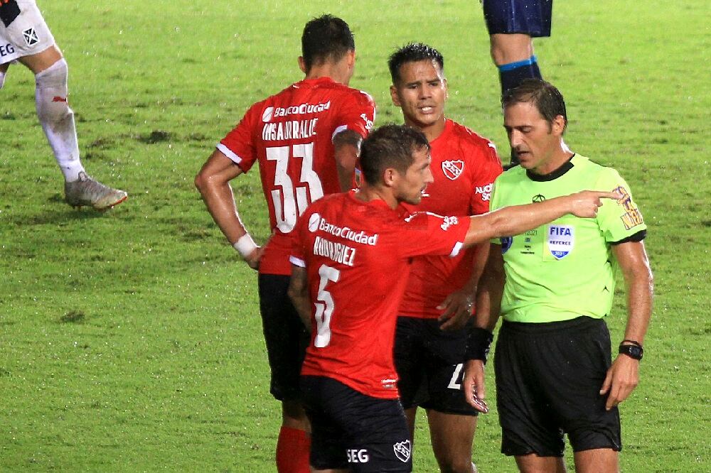 Vigliano ya pitó el penal y escucha las quejas de los jugadores de Independiente.
